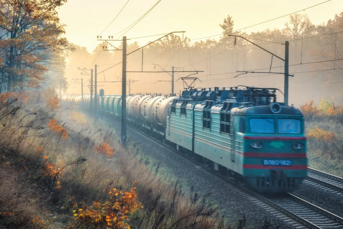 Freight train travelling through an autumn landscape